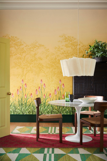 Dining room with yellow mural wallpaper (Upper Brook Street - Soleil) and a dining room table with wooden chairs.