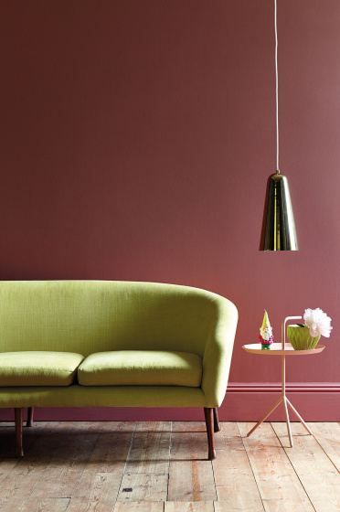 Living room painted in mid pink shade 'Ashes of Roses' with a lime green sofa on a wooden paneled floor.