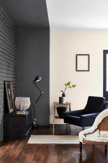 Living room with dark grey painted brickwork (Scree) with an off white wall and two armchairs facing a sidetable.