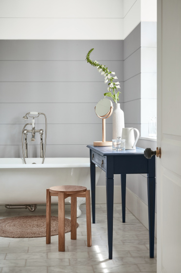 Bathroom painted in dark grey (Gauze - Dark) with a white bathtub and contrasting blue black (Basalt) side table.