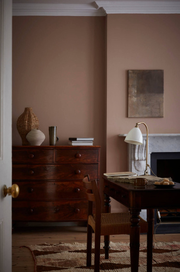 Home study space painted in muted pink shade 'Mochi' with a wooden chest of drawers, desk and chair.