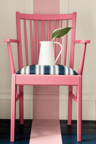Dark pink (Carmine) chair with a dusky pink stripe painted from the wall down to the navy blue panelled floor.