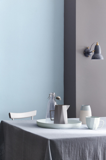 Dining room painted half in blue grey (Arquerite) and half in light blue (Pale Wedgwood) with a table and crockery on top.