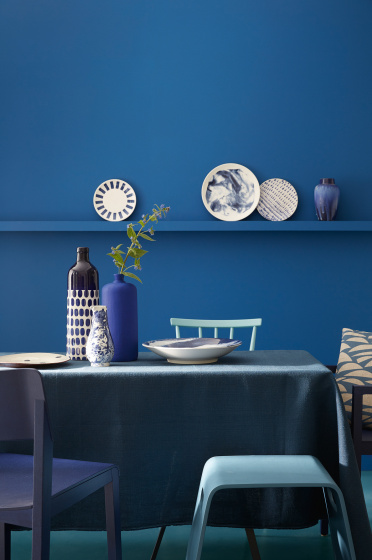 Dining room color drenched in rich blue 'Mazarine' with a dining room table and chairs.