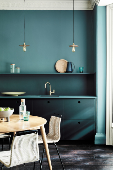 Kitchen painted in blue green (Tea with Florence) and dark green (Harley Green) with a round wooden table and chairs.