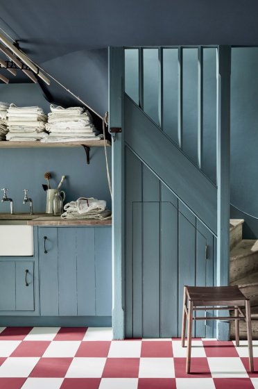 Laundry room painted in muted blue 'Etruria' with a sink, staircase and checkered floor tiles.